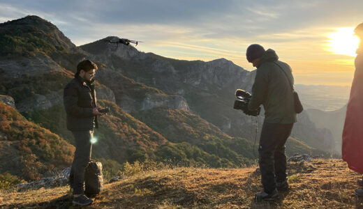 山岳地帯でドローン撮影を行う撮影スタッフ