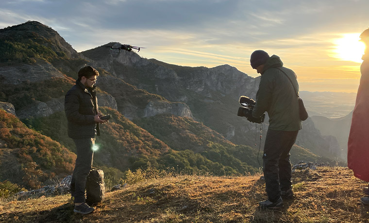 山岳地帯でドローン撮影を行う撮影スタッフ